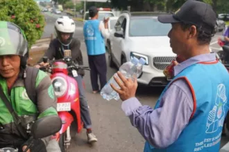 Pedagang asongan menggenakan rompi hasil daur ulang platik botol air mineral. (foto: ist)