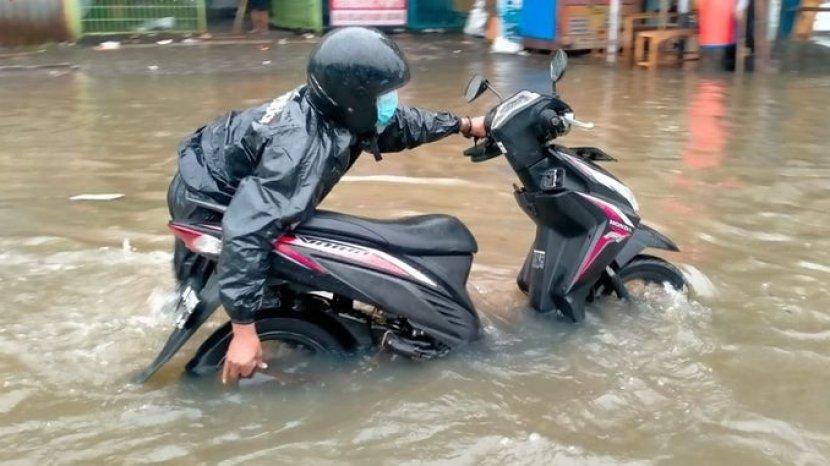 Perlu kewaspadaan bagi para pengendara motor dan sebisa mungkin untuk menghindari dan tidak memaksakan menerobos genangan banjir karena memiliki berbagai macam risiko. (Foto: Tribunnews)