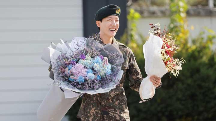 Anggota boy band K-pop BTS, J-Hope, tersenyum sambil memegang bunga setelah dibebastugaskan dari wajib militer selama 18 bulan di luar pangkalan militer di Wonju, Korea Selatan, 17 Oktober 2024. (Foto: REUTERS/Kim Soo-hyeon)