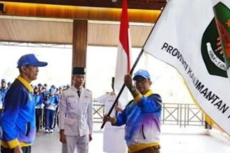 Pj Gubernur Kaltim Akmal Malik menyerahkan pataka bendera Kaltim kepada Ketua NPCI Kaltim Suharyanto menandai pelepasan atlet mengikuti Peparnas ke-17 di Solo, Jawa Tengah. (FOTO: Diskominfo Kaltim)