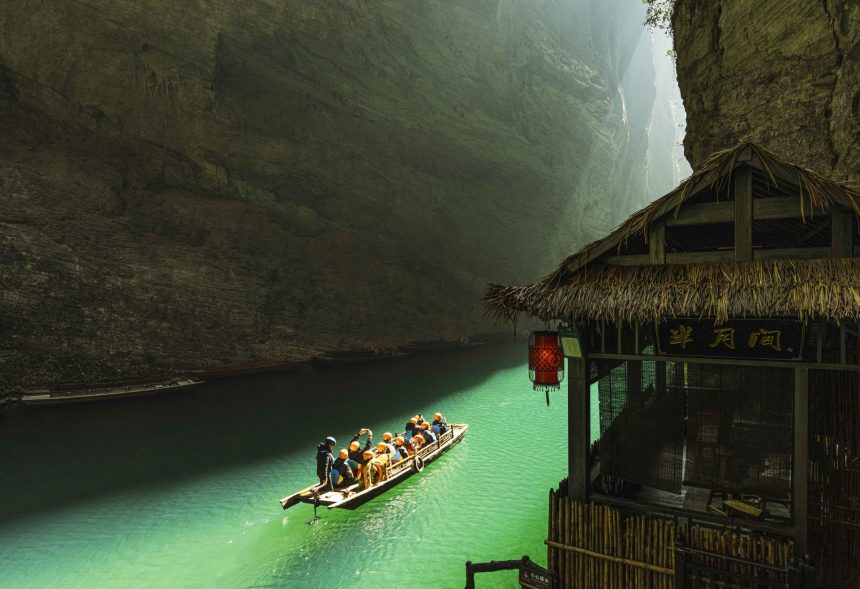 Para turis menikmati wisata perahu di ngarai Pingshan, sebuah objek wisata yang terkenal dengan kejernihan airnya, di wilayah Hefeng, Provinsi Hubei, China tengah, (FOTO: Xinhua/Qin Tao).